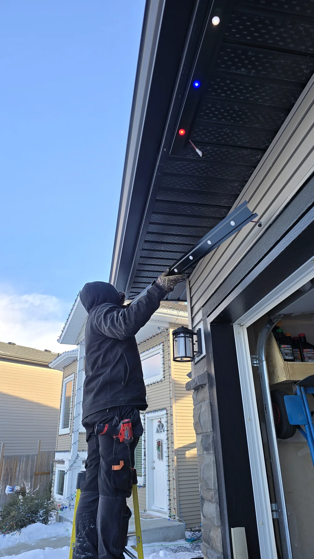 Verity electrician installing permanent roofline lighting on a Calgary Area home